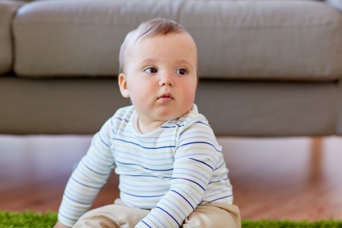 baby boy sitting on floor at home