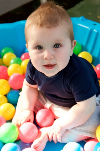 cute little baby boy having fun in ball pit