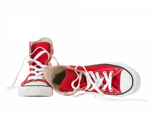 Vintage red sneakers fallen on the ground on white background